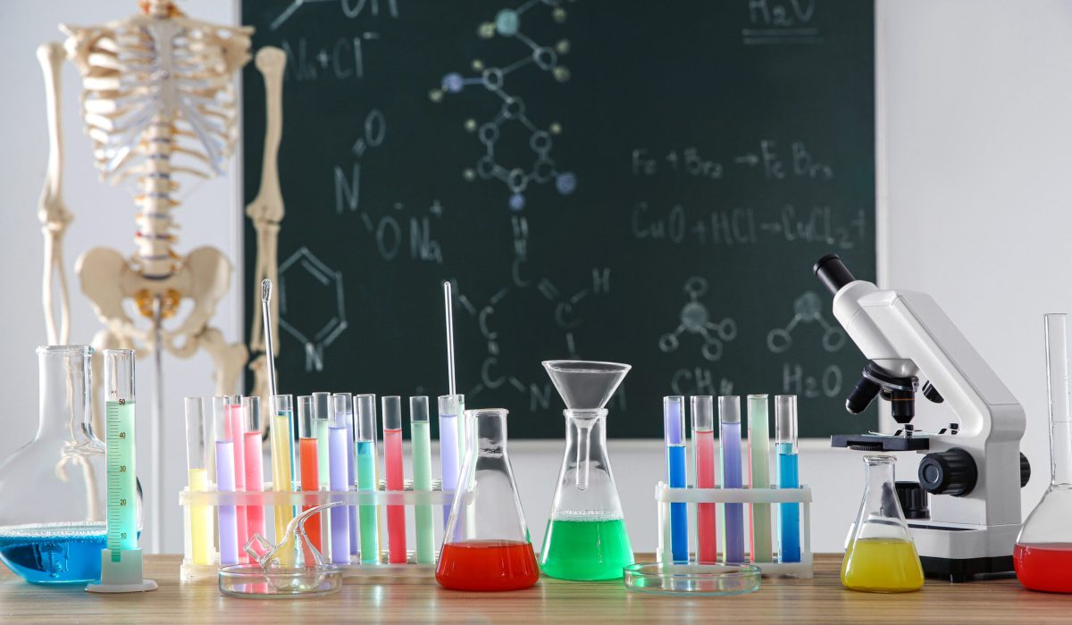 Different chemistry glassware on table in classroom